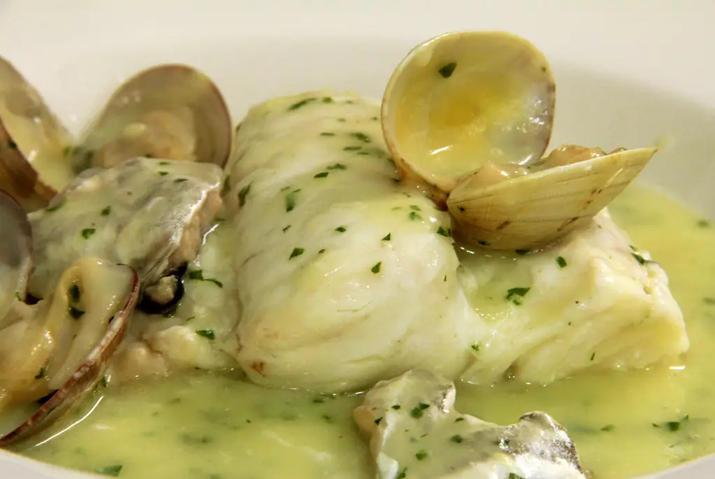 Merluza en salsa verde con kokotxas y almejas