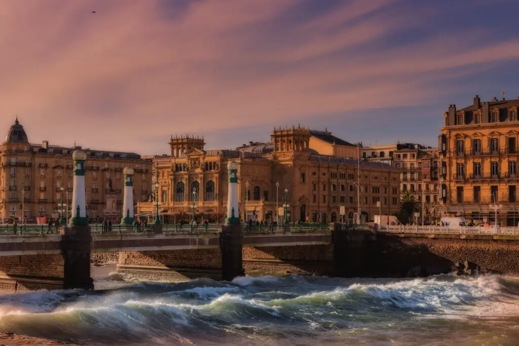 Charming view of a bridge and historic architecture in San Sebastián during sunset.